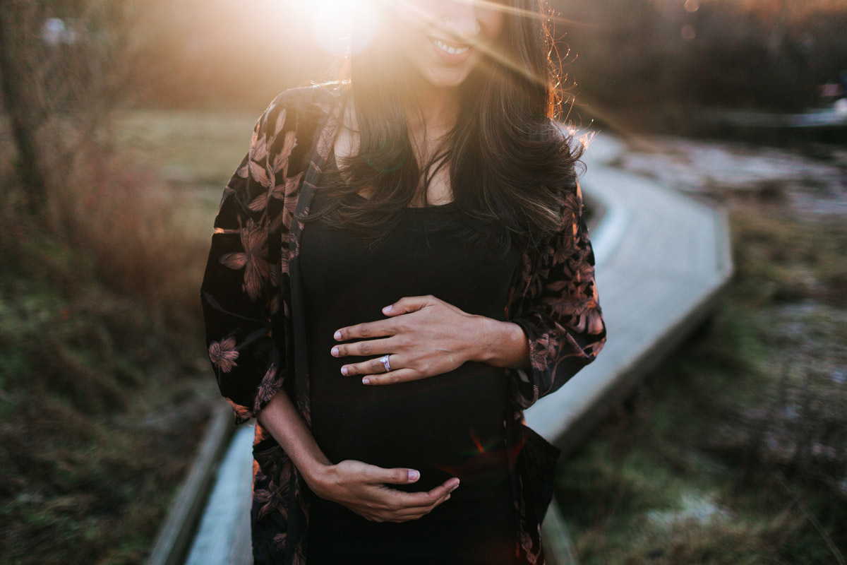 Canadian gestational surrogate holding her pregnant belly